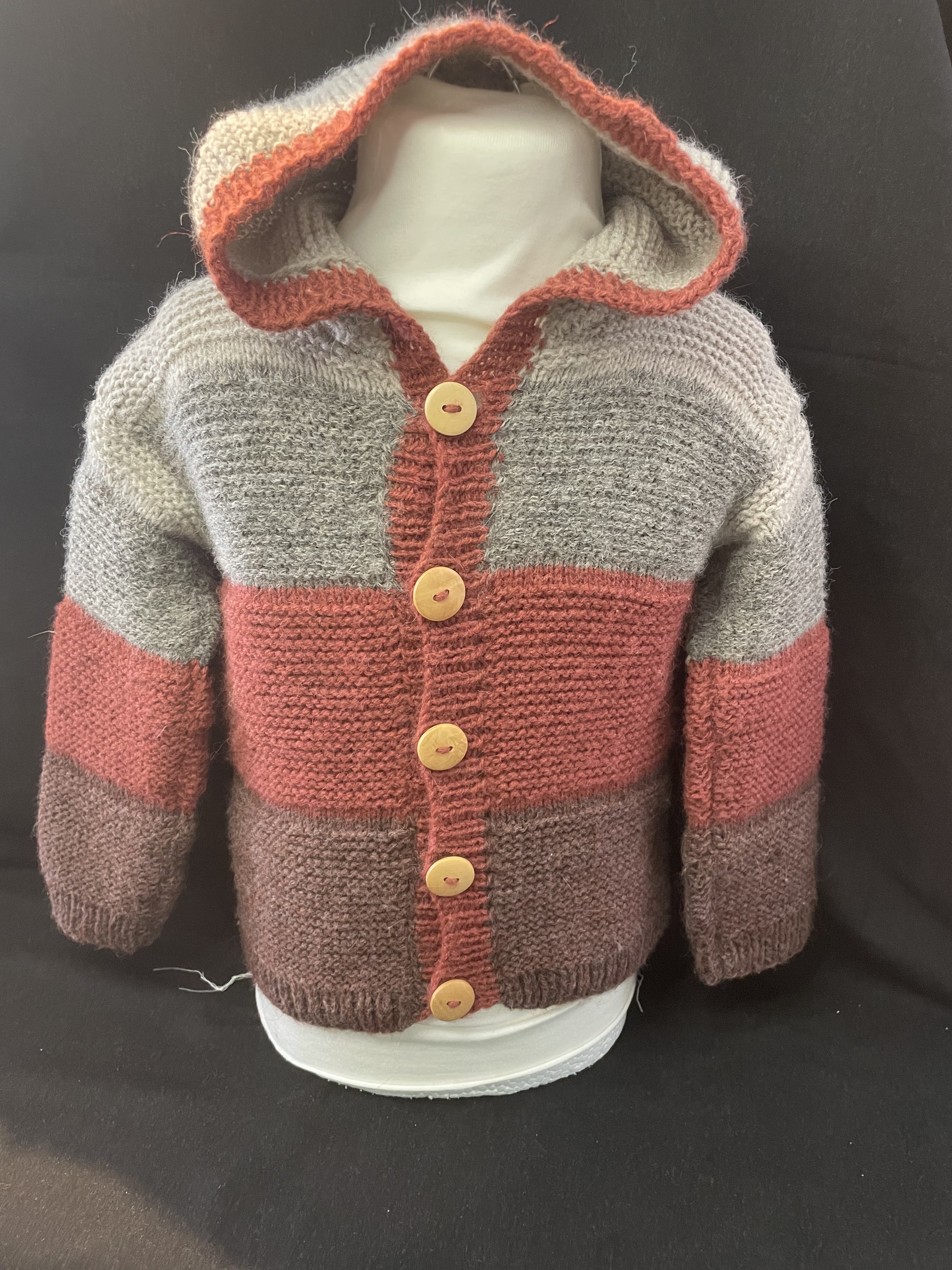 Handgestrickte Baby-Strickjacke mit Kapuze in Grau, Rost und Braun mit Holzknöpfen, warme Herbst- und Winterjacke für Babys
