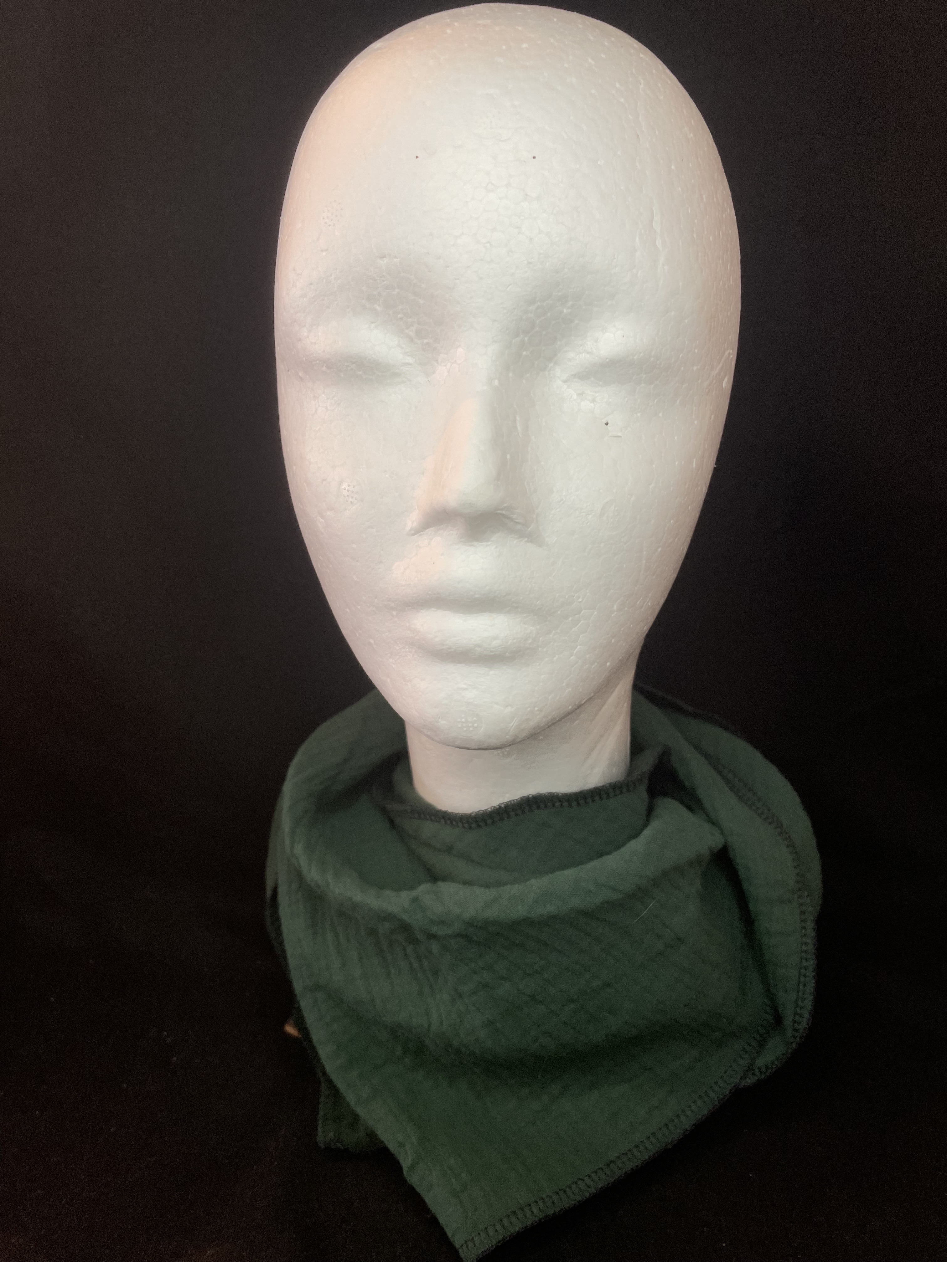 Dunkelgrünes Musselin Dreieckstuch mit dunkler Overlocknaht locker um den Hals getragen