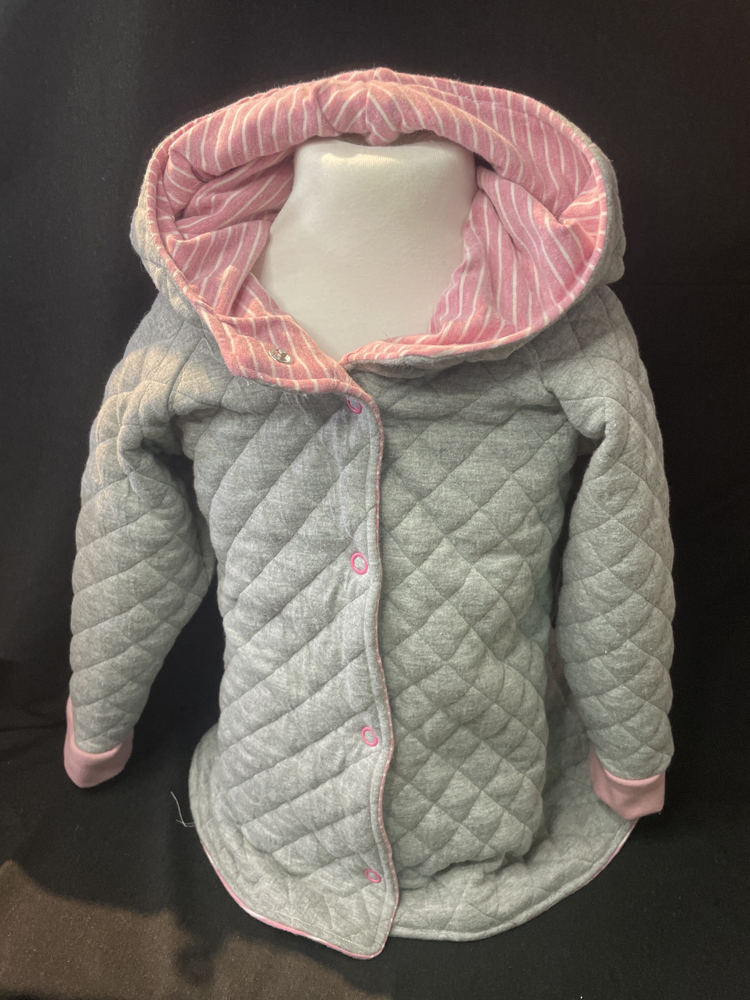 Grau gesteppte Babyjacke mit rosa Kapuzenfutter. Warm, bequem und ideal für Herbst & Frühling. Jetzt online entdecken!