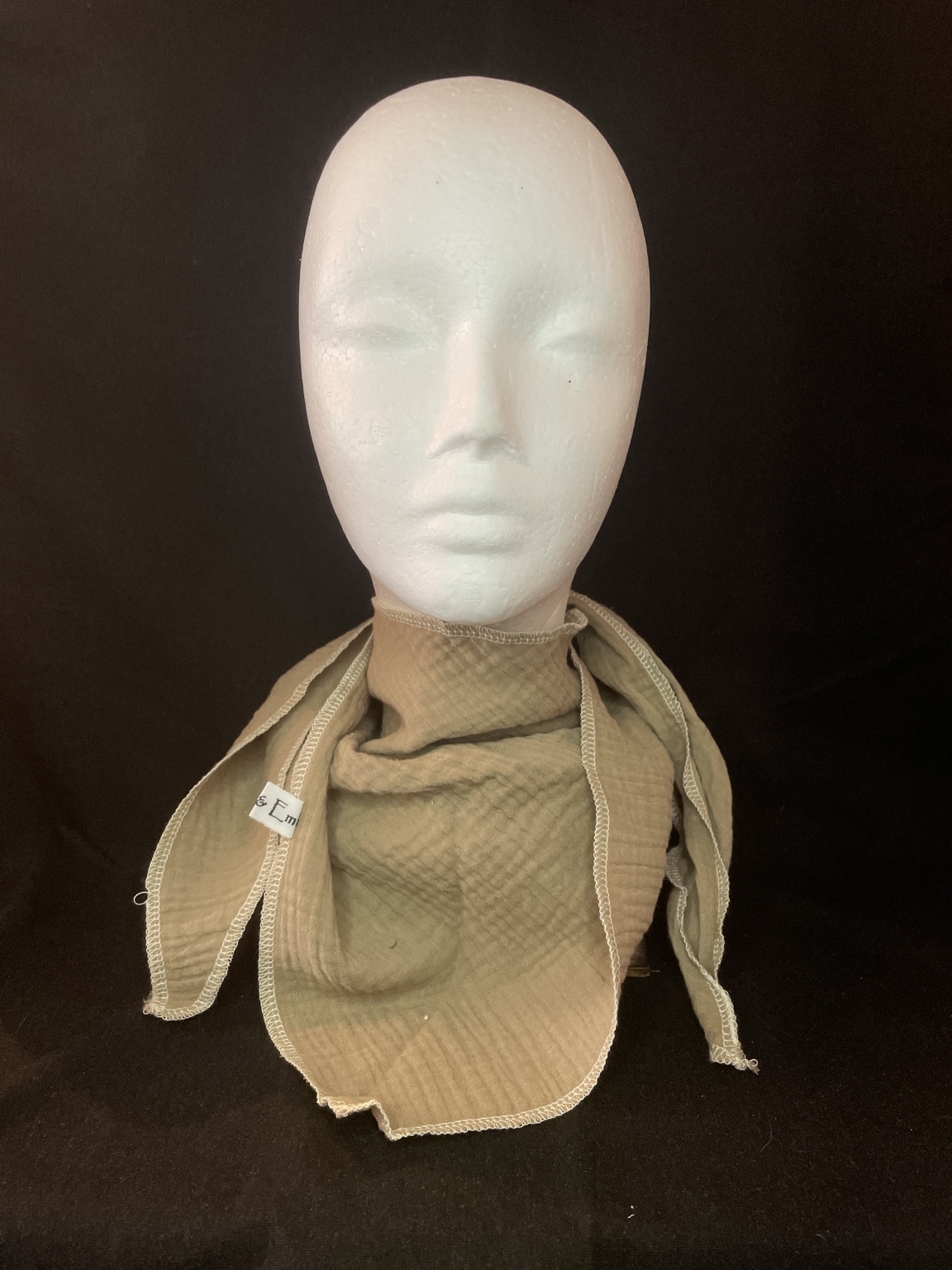 Naturbeiges Musselin Dreieckstuch mit heller Overlocknaht locker um den Hals getragen