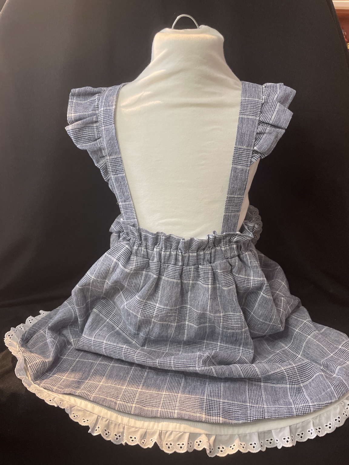 Blau-weiß karierter Mädchen Trägerrock mit überkreuzten Trägern, Volants und Spitzenabschluss im Vintage-Stil