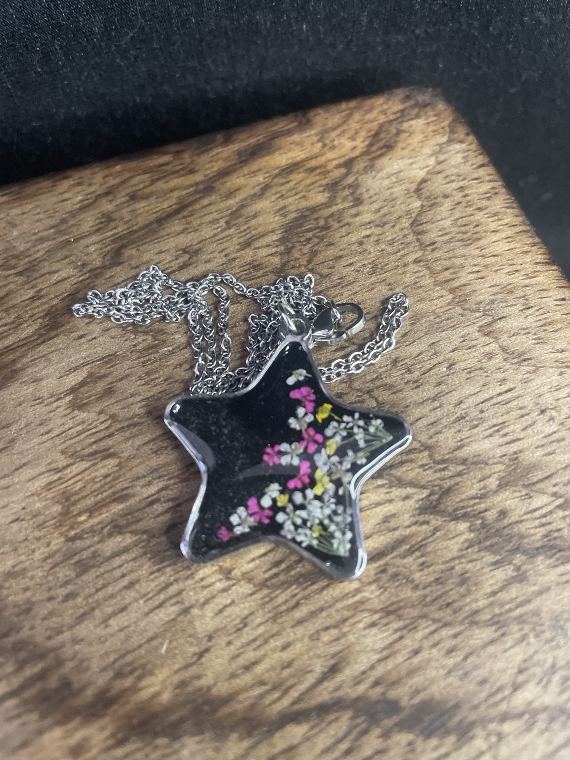 Handgefertigte Stern-Halskette mit echten Blüten im schwarzen Resin-Anhänger