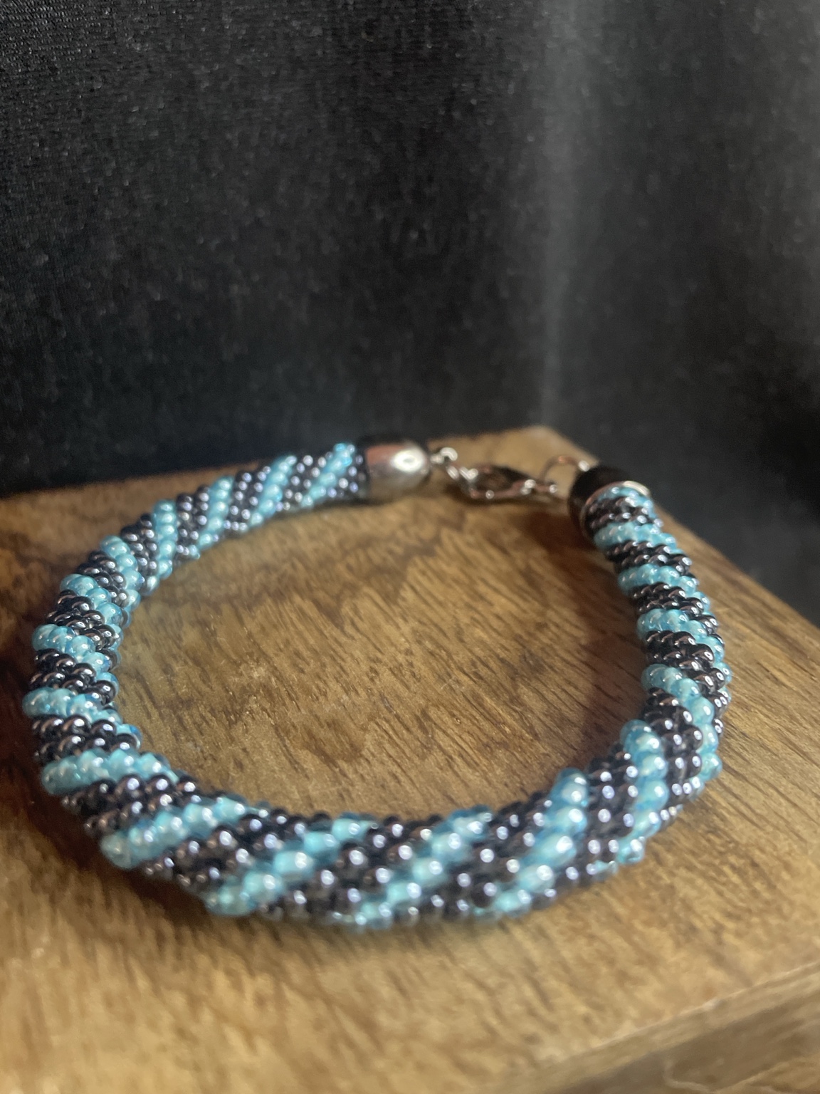 Handgefertigtes Glasperlenarmband in Türkis und Schwarz mit Spiraldesign und Karabinerverschluss