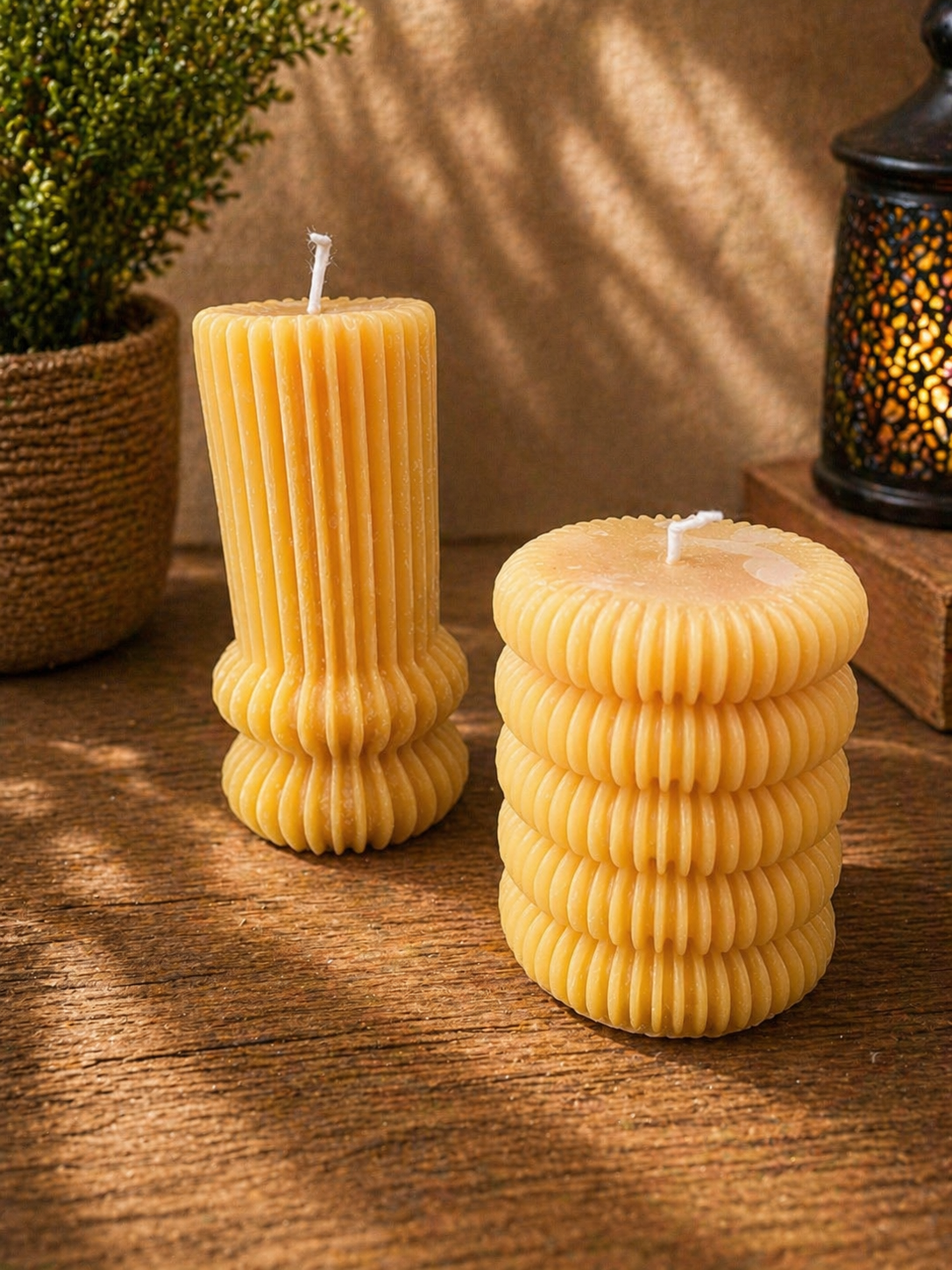 Gerillte Designkerze aus Bienenwachs in natürlichem Farbton auf Holztisch dekoriert