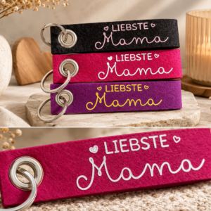 Filz-Schlüsselanhänger mit Liebste Mama Schriftzug in verschiedenen Farben auf dekorativem Untergrund