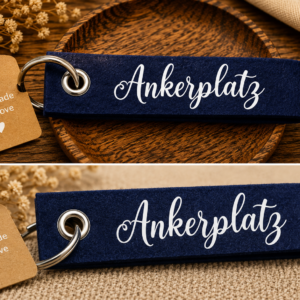 Dunkelblauer Filz-Schlüsselanhänger mit Ankerplatz Schriftzug auf dekorativer Holzschale
