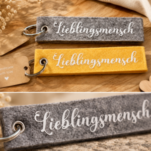 Filz-Schlüsselanhänger mit Lieblingsmensch Schriftzug in verschiedenen Farben auf Holzuntergrund
