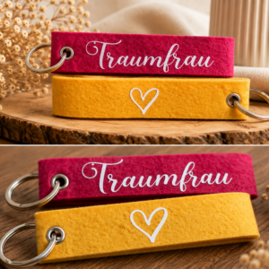 Filz-Schlüsselanhänger mit Traumfrau Schriftzug in Pink und Gelb auf Holzuntergrund