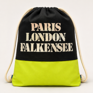 Handgefertigter Turnbeutel aus schwarzem Stoff mit neongelbem Unterteil und dem Aufdruck „Paris London Falkensee“.
