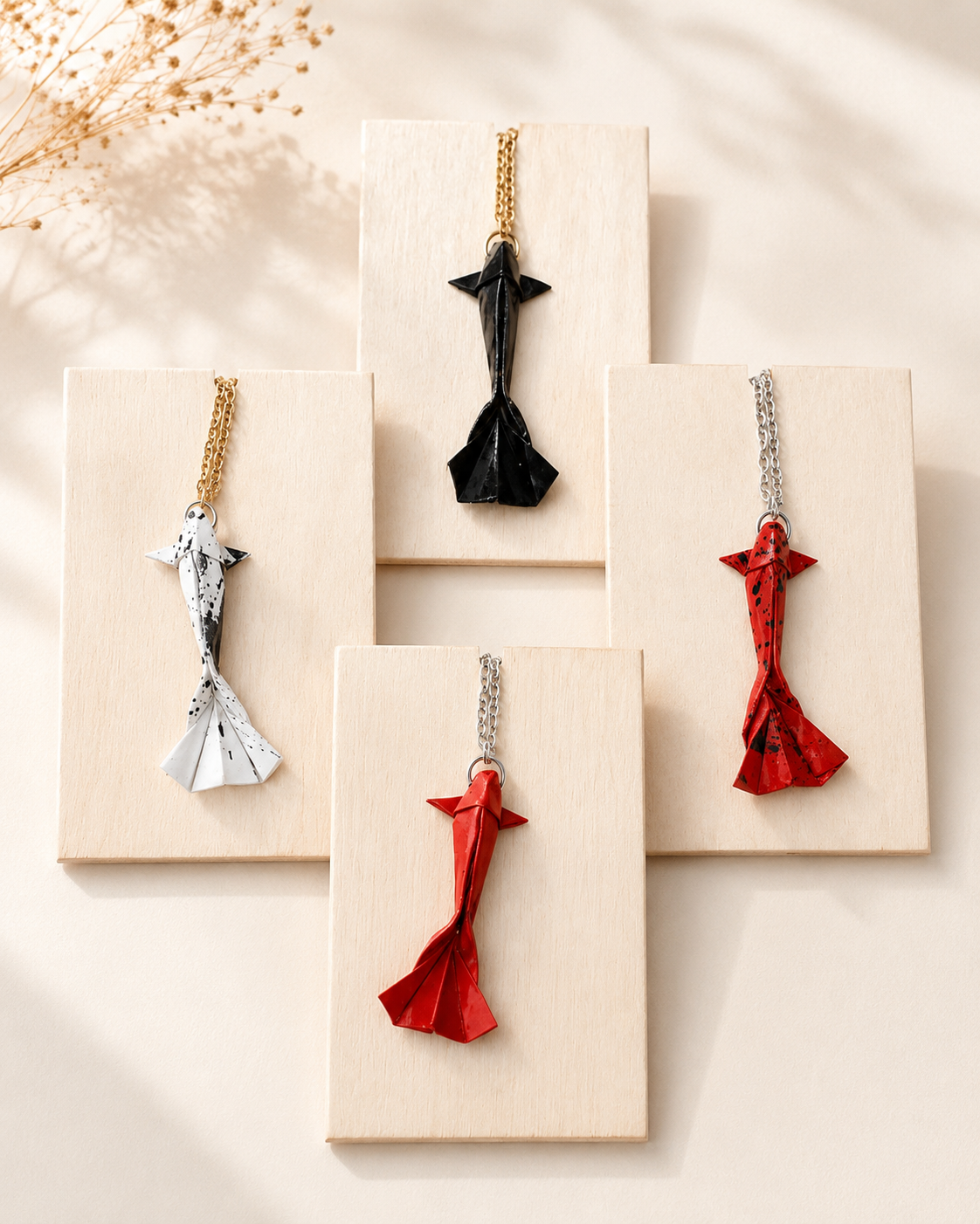 Handgefertigte Origami Koi Halsketten in verschiedenen Farben auf hellen Schmuckkarten präsentiert. Japanisch inspirierter Schmuck mit Koi-Anhänger.