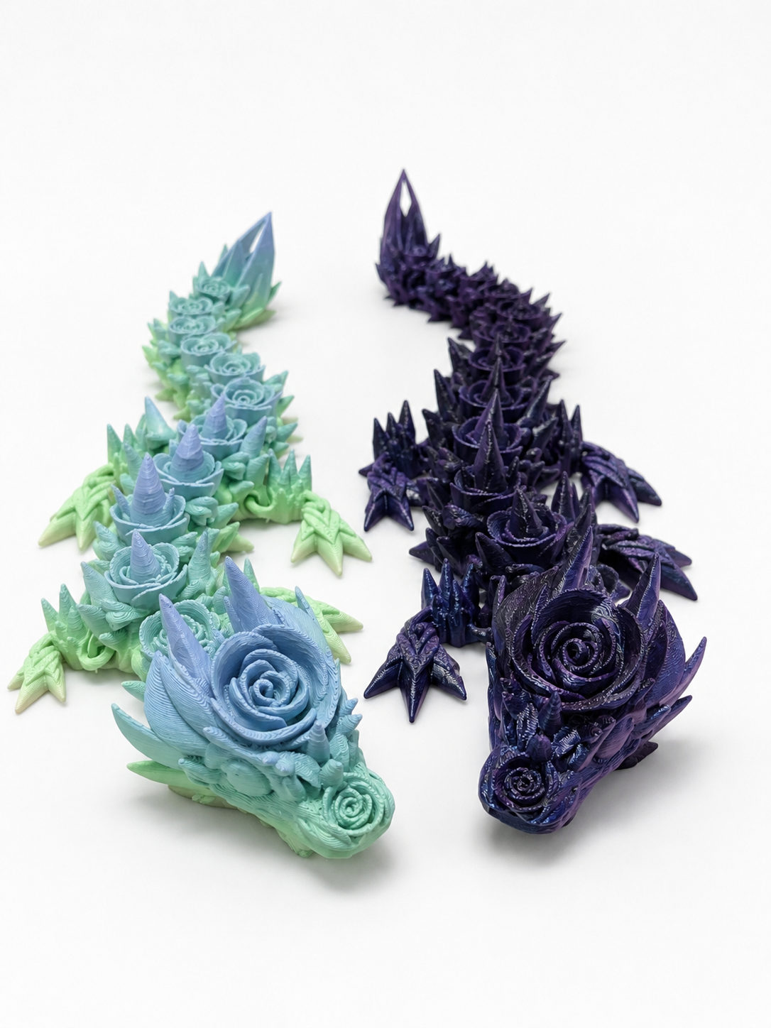 3D-gedruckter beweglicher Blüten-Drache mit Rosenverzierungen in verschiedenen Farbvarianten als dekorative Fantasy-Figur.