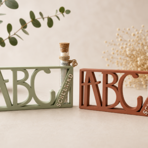 3D-gedruckter ABC-Aufsteller mit Schriftzug „Schulkind“ und Glasröhrchen mit Korkverschluss als Geldgeschenk zur Einschulung.
