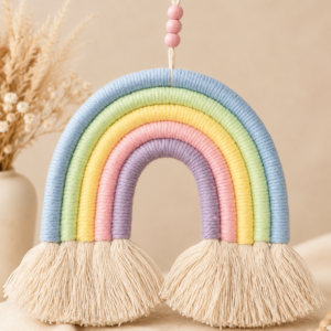 Handgefertigter Makramee-Regenbogen in Pastellfarben mit Baumwollfransen und Holzperlen als Aufhängung – dekorativer Wandbehang für Baby- und Kinderzimmer.