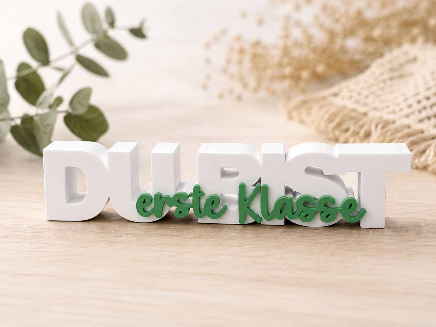 3D-gedruckter weißer Schriftzug „Du bist“ mit grünem Schriftzug „erste Klasse“ als freistehende Dekoration zur Einschulung.
